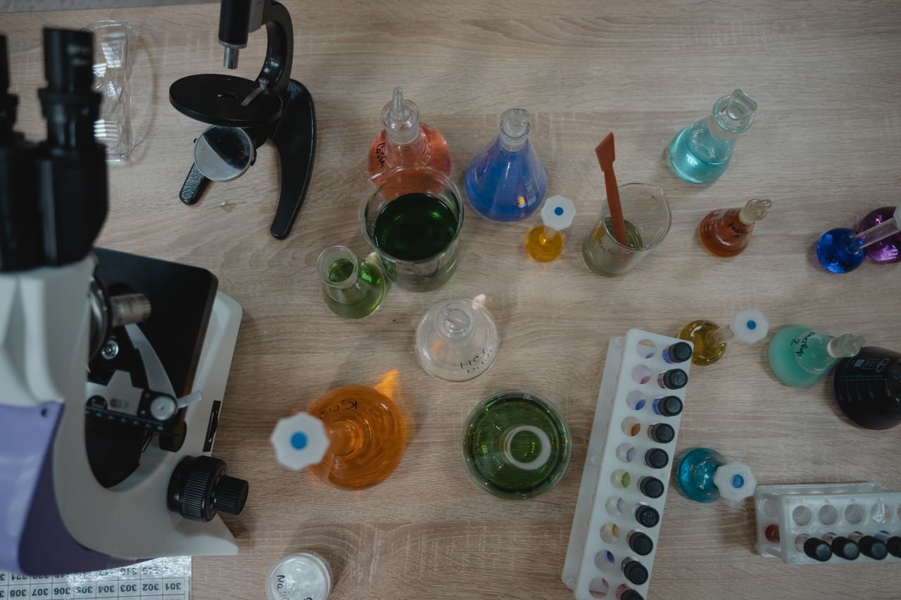 Colorful chemistry lab with test tubes and a microscope viewed from above.
